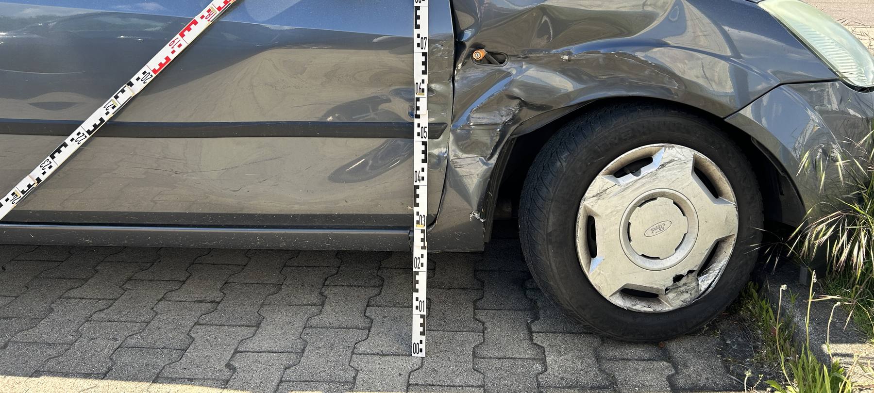 Aufnahme der eingedrückten rechten Seite eines Ford Fiesta mit zwei angelegten Messlatten, Kalkulation 11.176,08 €
