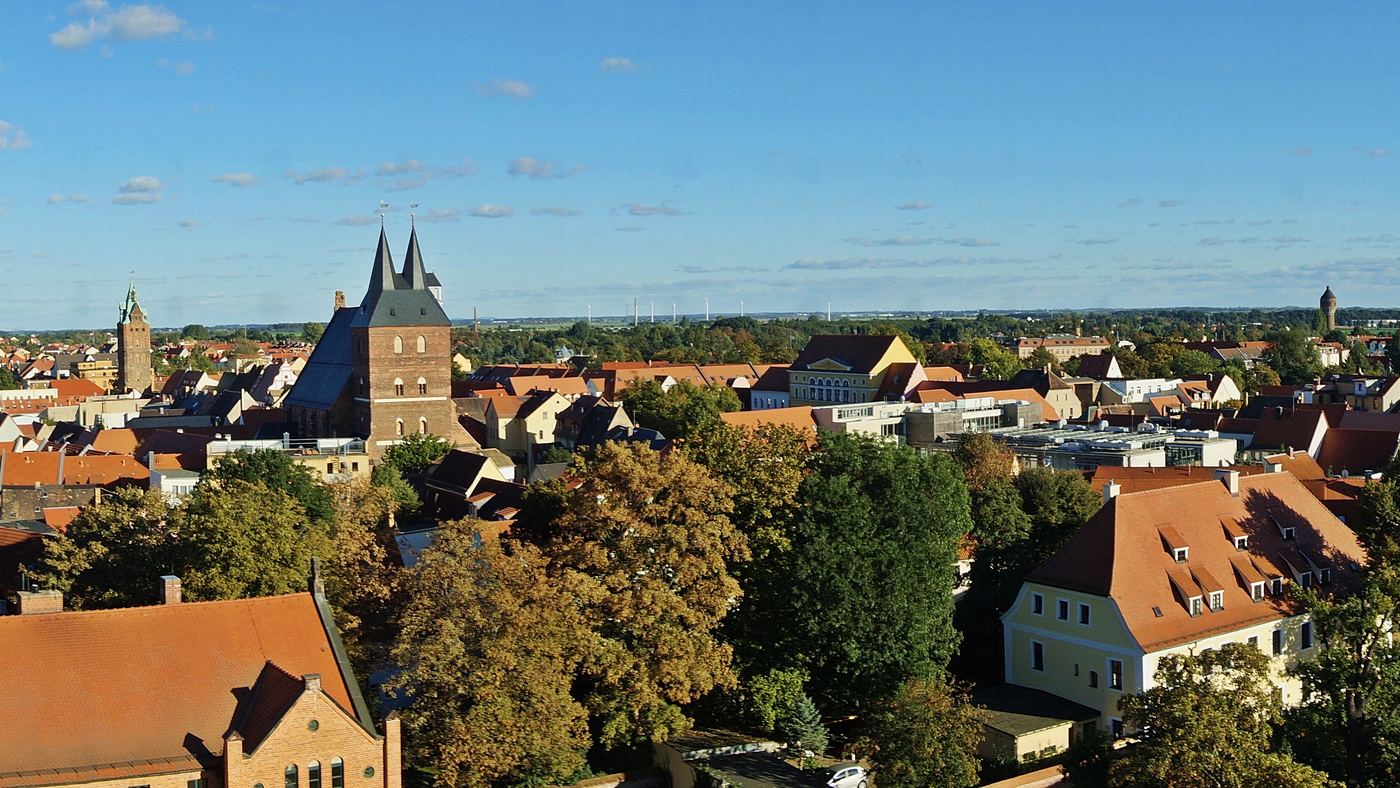 Blick vom Turm des Barockschlosses über die Delitzscher Altstadt mit den beiden Türmen von St. Peter und Paul und dem Wasserturm im Hintergrund